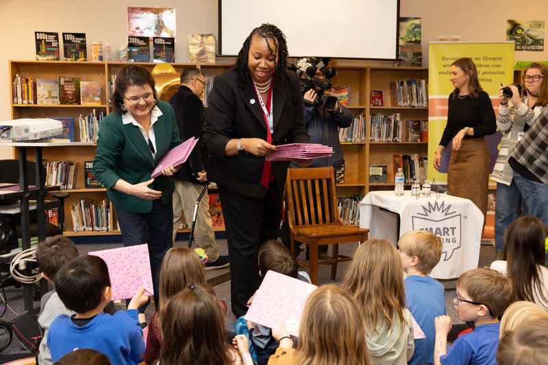 Amy Kotek Wilson and Dr. Kimberlee Armstrong distribute books to Hayhurst students.
